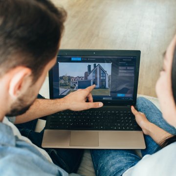 Two people looking at housing plans on a tablet